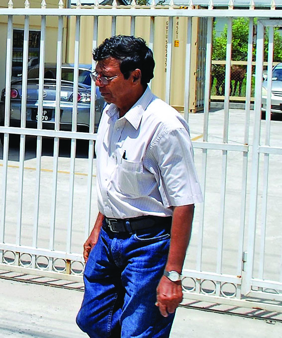 Sheik Baksh walking away from media operatives outside of SOCU headquarters