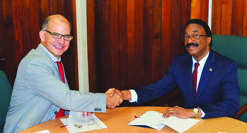 USAID’s General Development Director Ted Lawrence and Attorney General Basil Williams after signing the pact on Thursday 