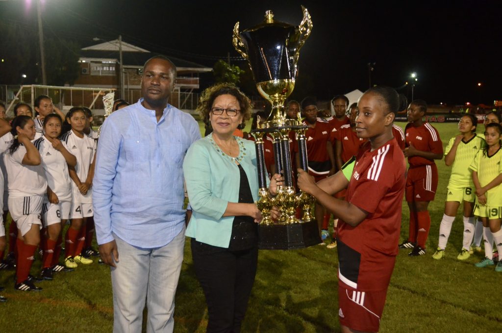 Minister within the Ministry of Indigenous Peoples’ Affairs Valerie Garrido-Lowe (centre) hands over the winning trophy to Guyana Defence Force Captain while GFF President Wayne Forde (left) shares the moment 