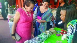 First Lady Sandra Granger and THAG President Andrea De Caires examining some of the products on display at the exhibition  