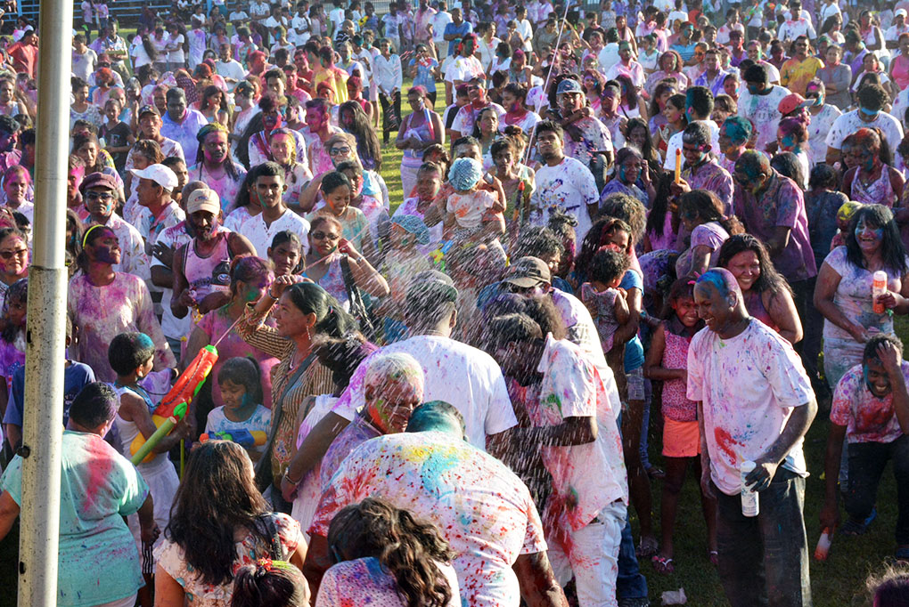 A large gathering of people celebrating the festival of holi at Everest Cricket Ground