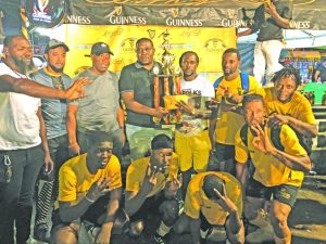 Banks DIH Linden Branch Manager Sean Grant presenting the championship trophy to the victorious Swag Entertainment in the presence of teammates and tournament officials