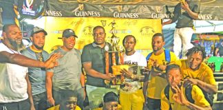 Banks DIH Linden Branch Manager Sean Grant presenting the championship trophy to the victorious Swag Entertainment in the presence of teammates and tournament officials